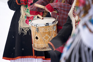 playing the drums in close-up in national costumes