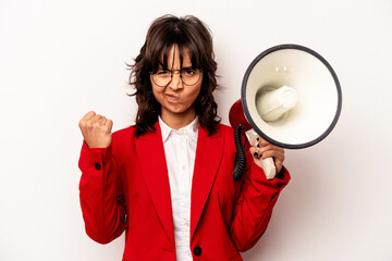 Young business hispanic woman holding an megaphone isolated on white background showing fist to camera, aggressive facial expression.