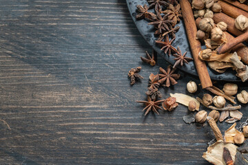 Food, Spices and Ingredent Concept. Flat lay top view of Chinese star anise, Cinnamon and Amomum krervanh with black plate on wooden table with copy space.