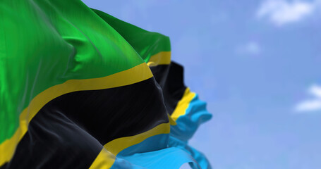 Detail of the national flag of Tanzania waving in the wind on a clear day.