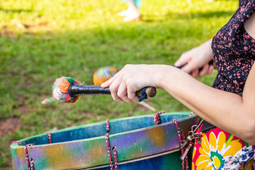 Detalhe de pessoa tocando instrumento de percussão.