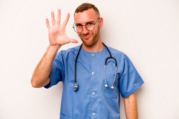 Young caucasian nurse man isolated on white background smiling cheerful showing number five with fingers.