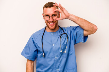 Young caucasian nurse man isolated on white background excited keeping ok gesture on eye.