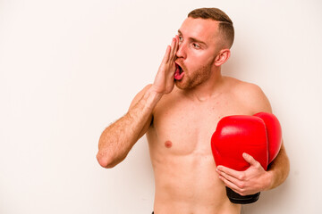 Young caucasian man doing boxing isolated on white background is saying a secret hot braking news and looking aside