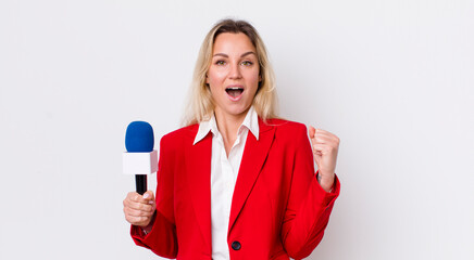 blonde pretty woman feeling shocked,laughing and celebrating success. preporter and microphone...