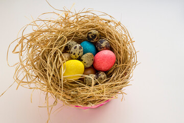 Decorative,colorful,Easter Eggs in nesting-box with quail eggs.Easter celebration concept