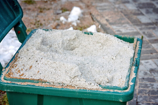 Open Salt Container, Salt And San For Slippery Surface Closeup. Container With Rock Salt Mixture Used In Cold Season To Sprinkle Sidewalks, Ice Melt, Slippery Prevention. Melting Snow And Ice