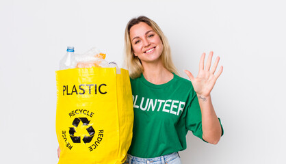 blonde pretty woman smiling and looking friendly, showing number five. recycle concept
