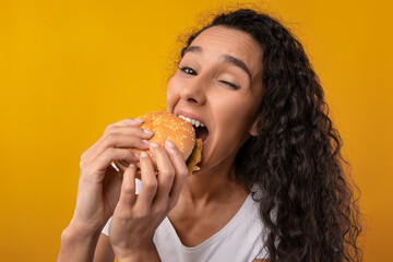 Funny Latin Lady Holding Burger Biting Sandwich At Studio