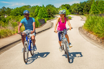 Afro American male and female cycling on road