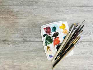 Multi-colored strokes, paint residues on the brushes and palette after painting. Close up on...