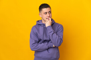 Fototapeta premium Young caucasian man isolated on yellow background nervous and scared