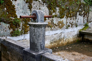 Taps. Old stone fountain with rusty pipes