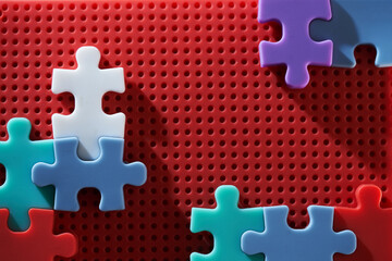 colorful jigsaw puzzle piece on red background