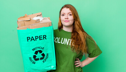 red head pretty woman smiling happily with a hand on hip and confident. recycling concept