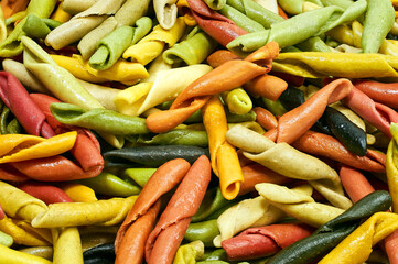 A pile of dry pasta of different colors in the form of tubes_03