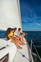 Obraz premium Hispanic children sitting with parents on luxury yacht