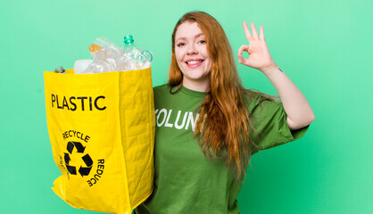 red head pretty woman feeling happy, showing approval with okay gesture. recycling concept
