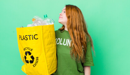 red head pretty woman on profile view thinking, imagining or daydreaming. recycling concept