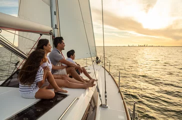 Fototapeten Hispanic family sailing on private yacht at sunset © Spotmatik