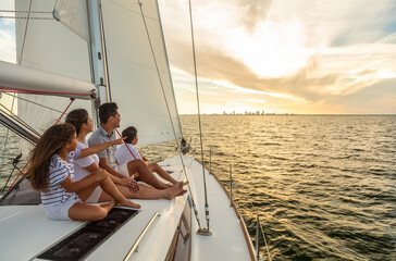Family sailing vacation at sunset on luxury yacht