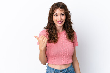 Young woman with curly hair isolated on white background pointing to the side to present a product