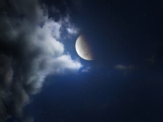 Large crescent moon in the night sky with stars and clouds. Natural satellite of the planet. 