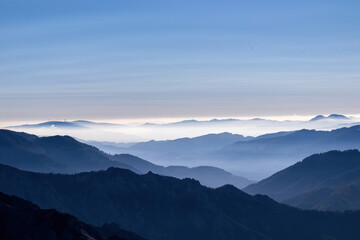 A panoramic view on the mountain peaks of the Hochschwab Region in Upper Styria, Austria. Cloudless weather on a sunny summer day in the Alps. Blue misty valley and soft hills. Concept freedom