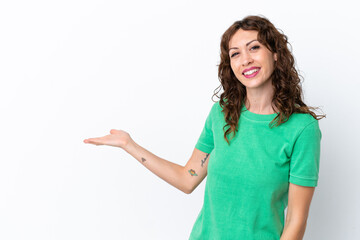 Young woman with curly hair isolated on white background extending hands to the side for inviting...