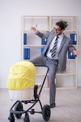 Young male employee looking after new born at workplace