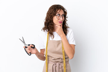 Young caucasian seamstress woman isolated on white background and looking up