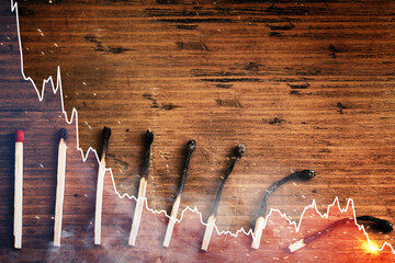 Undamaged and several progressively more burnt out match sticks and falling sparkline chart - obrazy, fototapety, plakaty