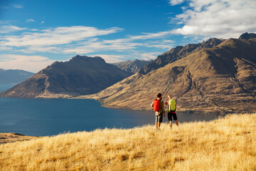 Fototapeta na wymiar Young hikers viewing Landscape Lake Wakatipu New Zealand