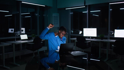 African-American businessman having neck ache working late in dark office