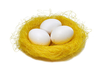 Golden and white colors eggs in straw nest on white background. Stylish bright egg for easter spring holiday. Decorative shiny Easter eggs minimal style card with copy space. Selective focus
