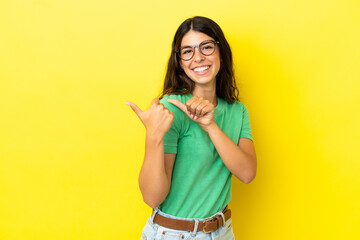 Young caucasian woman isolated on yellow background pointing to the side to present a product