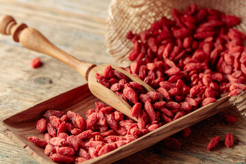 Dried goji berries on a wooden table.