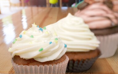 Sweet upcakes with cream cheese decorated with dried cinnamon powder. Homemade pastry