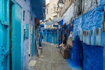 Morocco, Chefchaouen, Narrow alley and souvenirs for sale at blue buildings