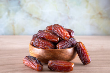 Bowl of dates fruit on wooden background	