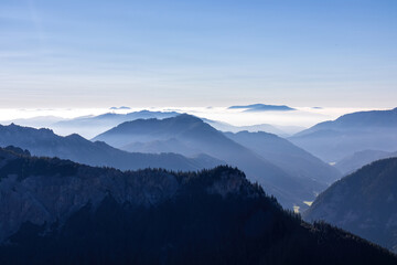 A panoramic view on the mountain peaks of the Hochschwab Region in Upper Styria, Austria. Cloudless weather on a sunny summer day in the Alps. Blue misty valley and soft hills. Concept freedom