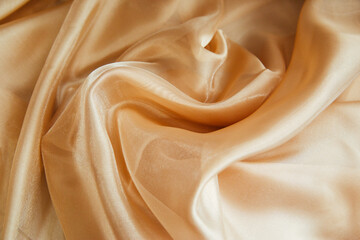 Golden fabric for drapery. A piece of cloth with folds. Crumpled Texture