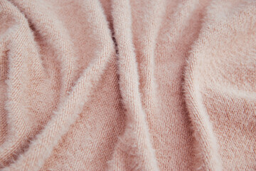 Fototapeta na wymiar Pink fluffy fabric for drapery. A piece of warm cloth with folds.