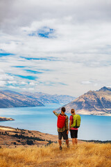 Naklejka premium The Remarkables young Caucasian couple trekking Lake Wakatipu