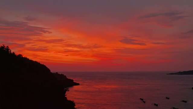 Beautiful nature landscape with scenery tropical island and fishing boat at colorful sunset Bali, Indonesia 4K Aerial view