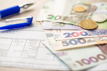 Close up photo of pen utility payments ukrainian hryvnia banknotes and coins