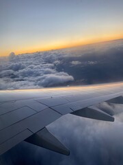 Fototapeta na wymiar Airplane wing. Sunset in the clouds on the plane.