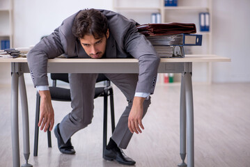 Young male employee in oversleeping concept