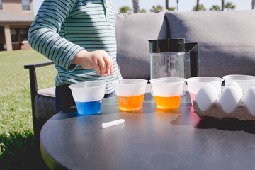 child decorating Easter eggs in the back yard stock photo royalty free