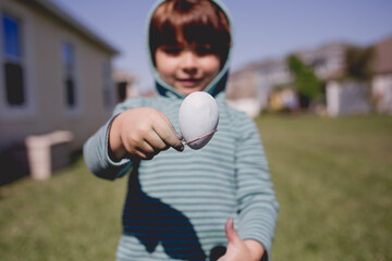 Easter egg dying in back yard.  Sweet child  coloring and painting eggs for Easter in garden, outdoors at home in backyard